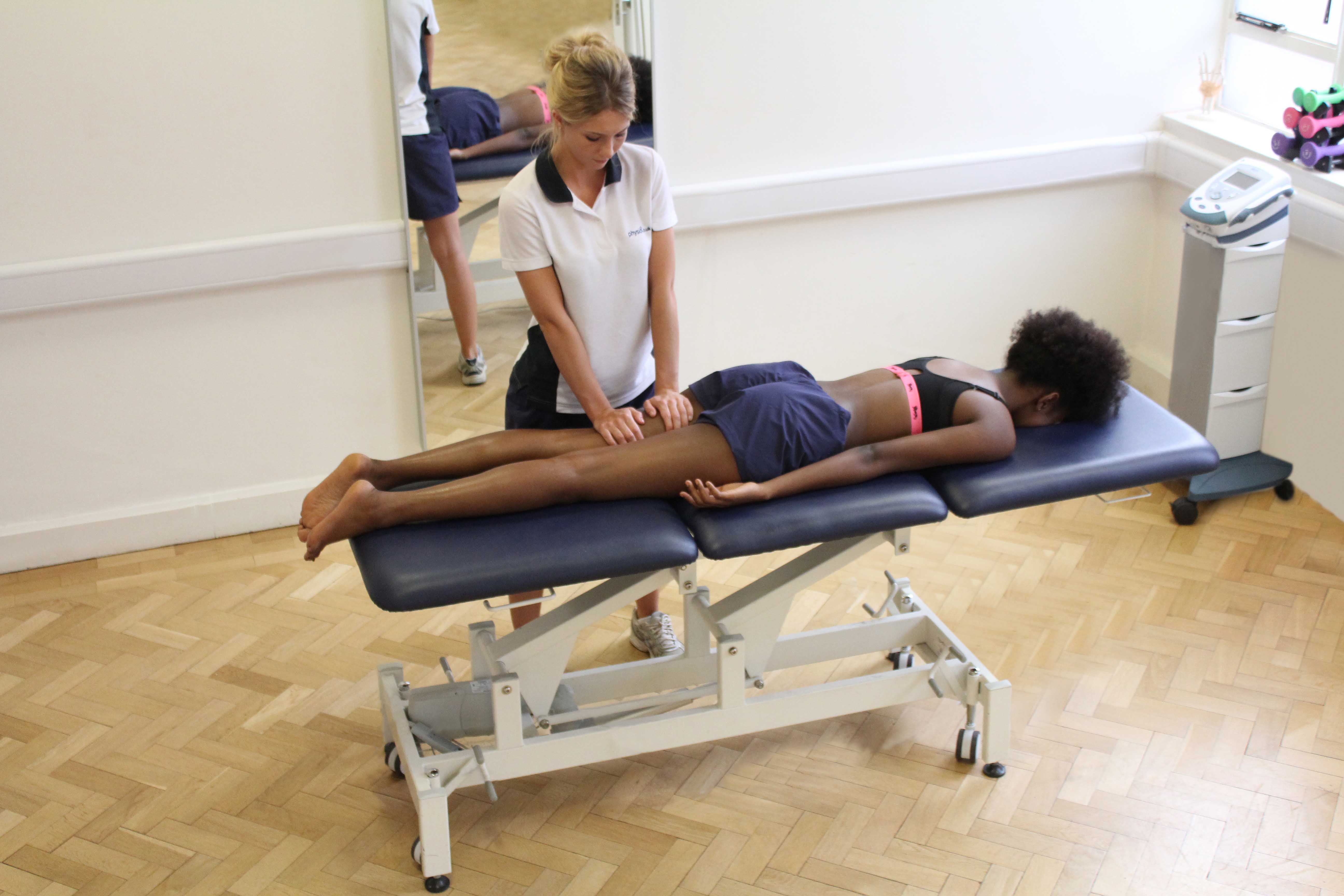 Compression massage applied to the hamstring muscles by experienced therapist