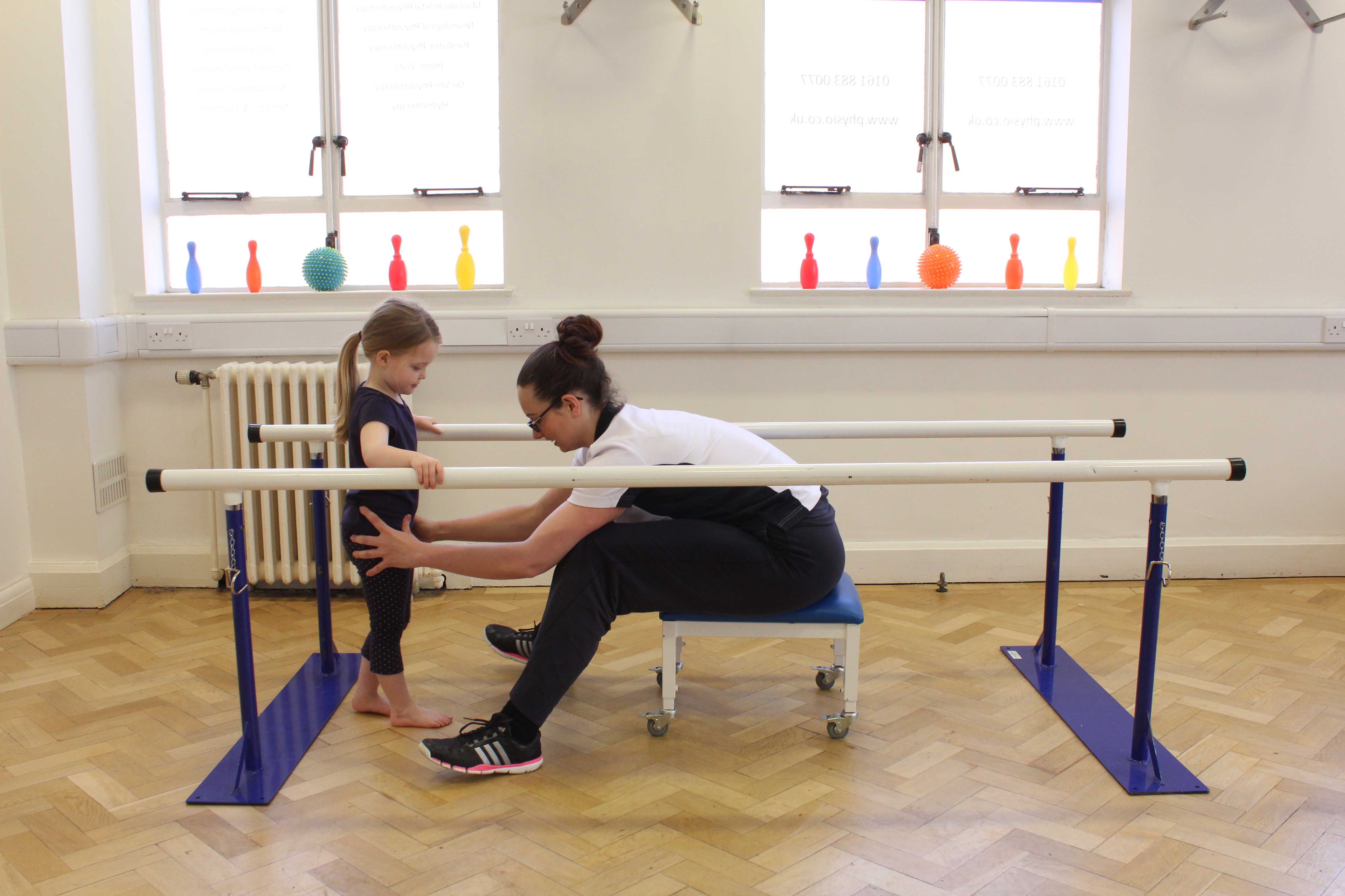 Mobility exercises between the parallel bars supervised by an experienced physiotherapist