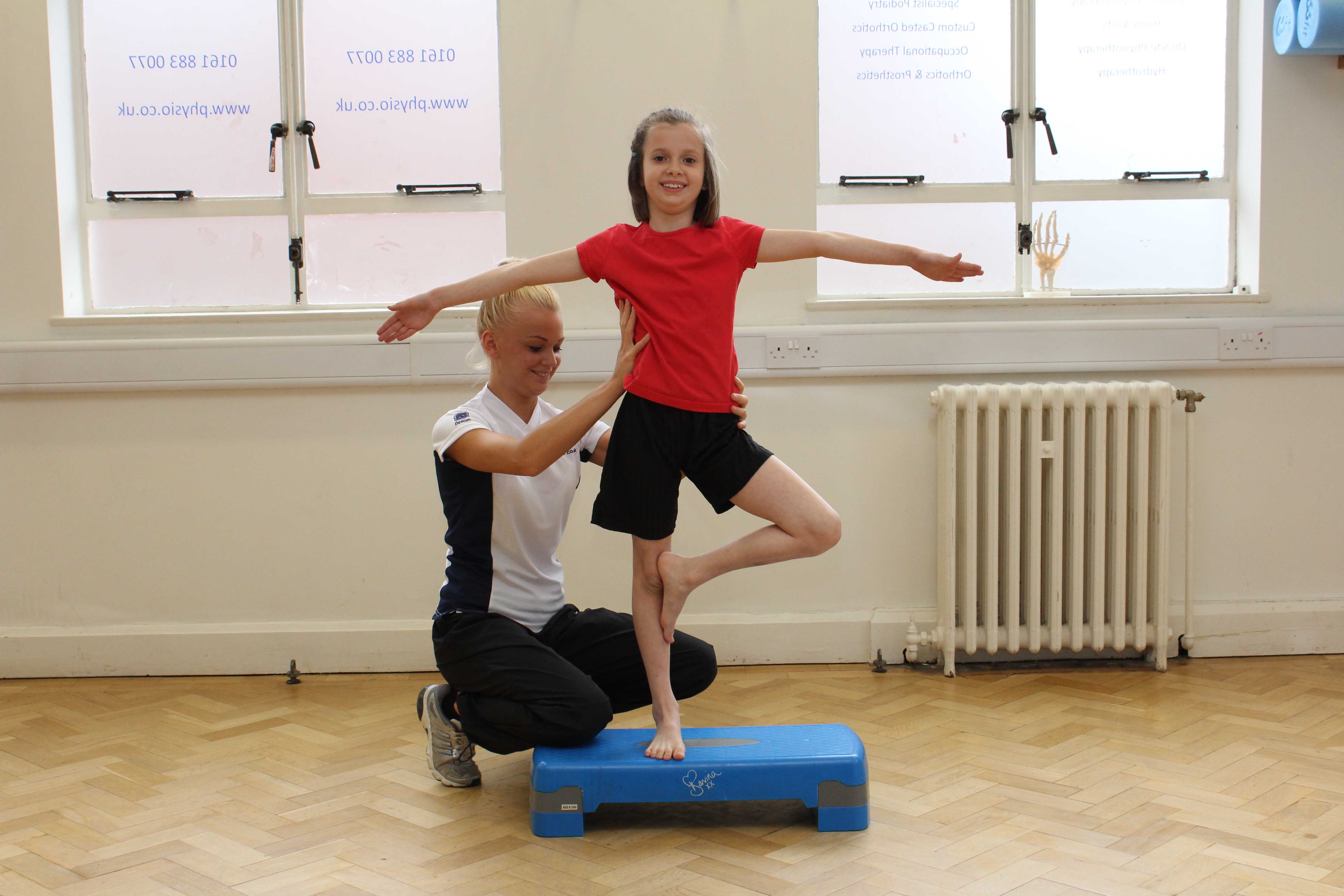 Therapist assists during progressive balance training exercises