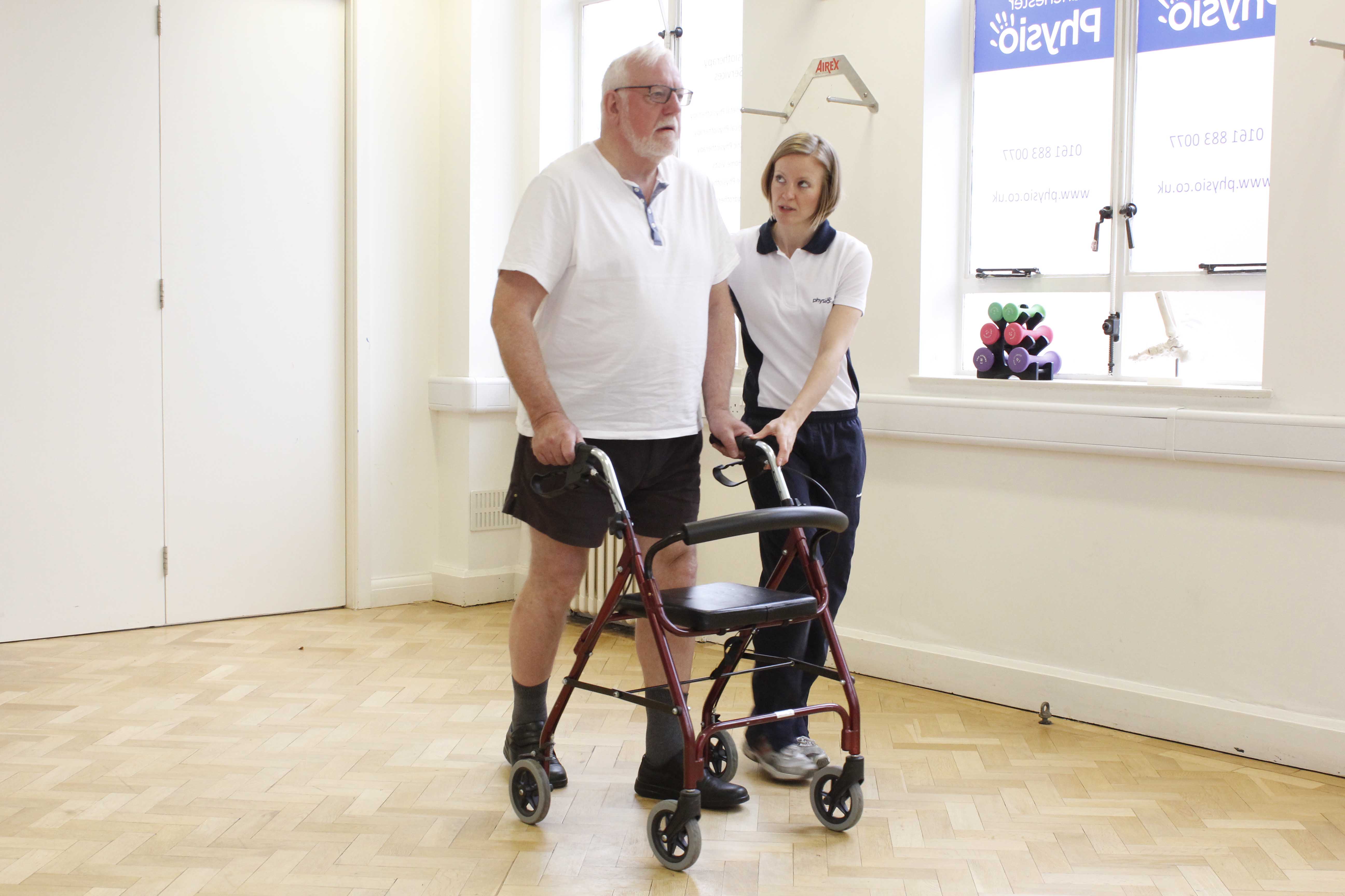 Mobility exercises using a rolator frame and close supervision of a physiotherapist