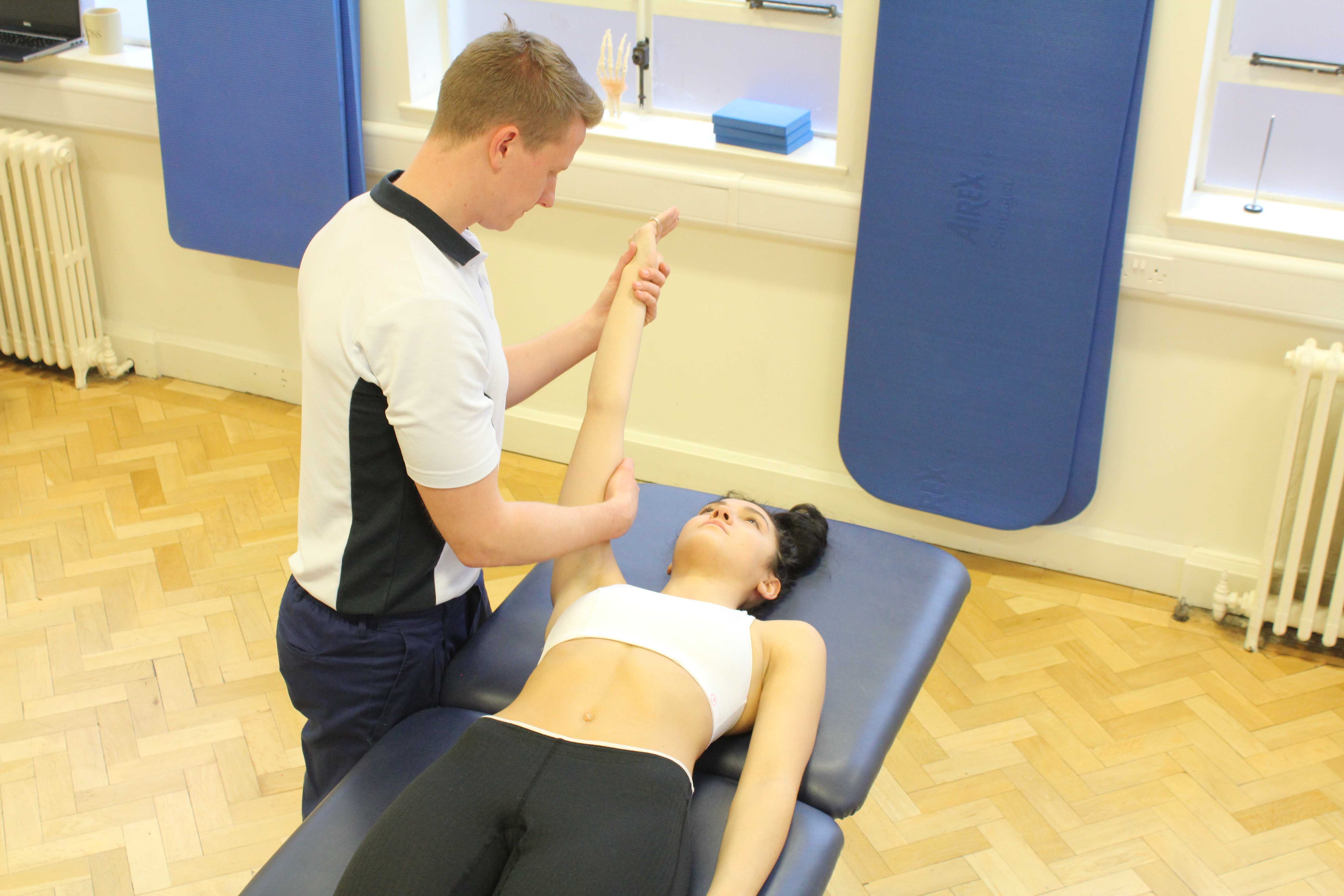 Experienced musculoskeletal physiotherapist assessing a limitation in shoulder movement