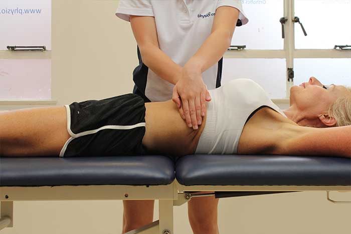 Customer reciving abdominal massage while in relaxed position in Manchester Physio Clinic