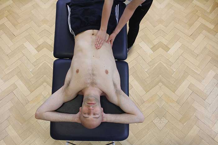Customer reciving abdominal massage while in relaxed position in Manchester Physio Clinic