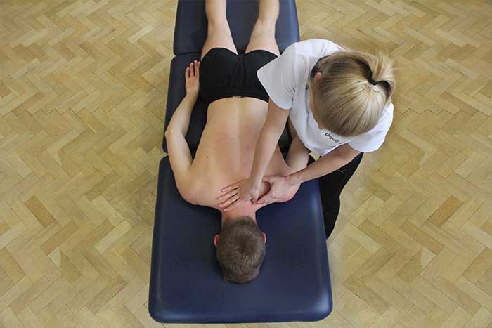 Customer receiving shoulder massage in relaxed position in Manchester Physio Clinic