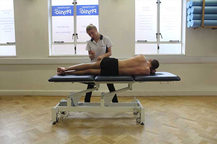 Customer receiving thigh massage while laying on his side in Manchester Physio Clinic