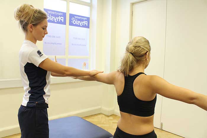 Customer reciving arm massage, while stretching in Manchester Physio Clinic