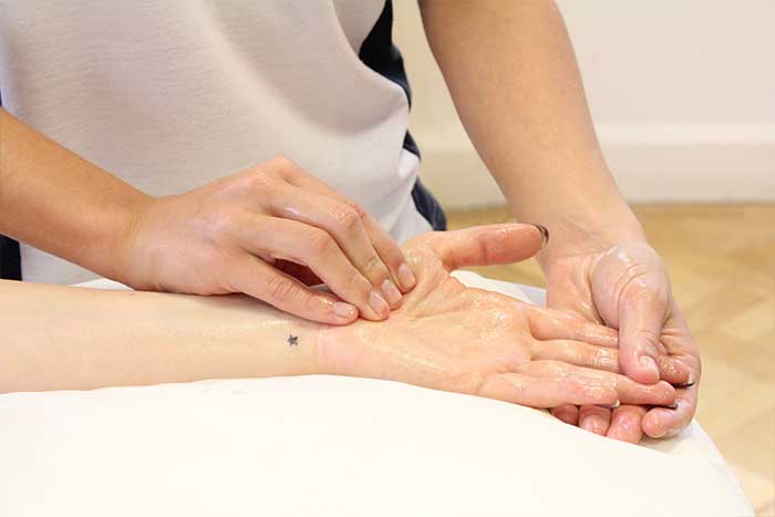 Customer reciving hand massage while in a relaxed position in Manchester Physio Clinic