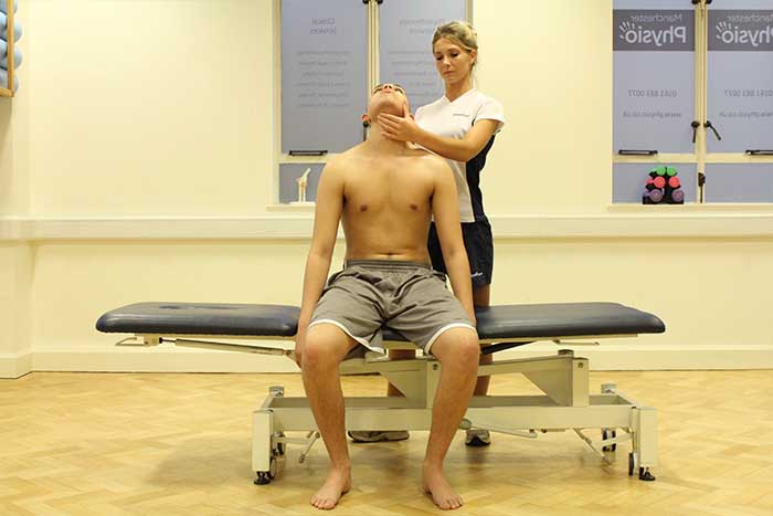 Customer receiving a jaw stretch while in a sitting position in Manchester Physio Clinic