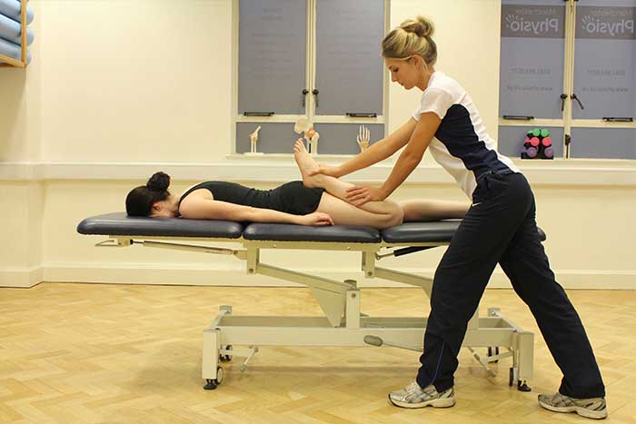 Customer receiving a calf stretch while in a relaxed position in Manchester Physio Clinic