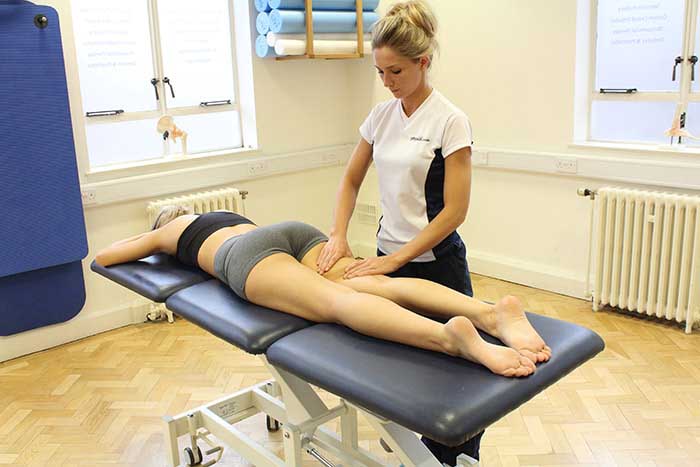 Customer receiving thigh massage while in a relaxed position in Manchester Physio Clinic