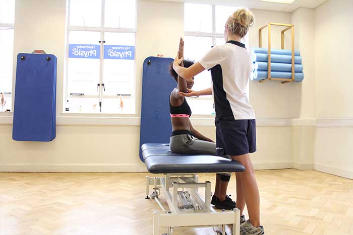 Customers arm lifted to increase strength and balance in arm in Manchester Physio Clinic