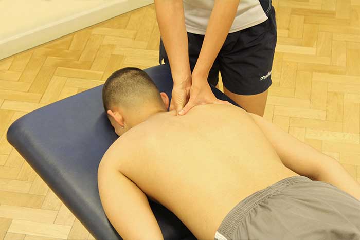 Customer reciving a shoulder massage while in a relaxed position in Manchester Physio Clinic