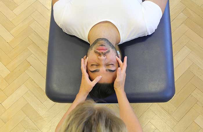 Customer receiving a head massage while in a relaxed position in Manchester Physio Clinic