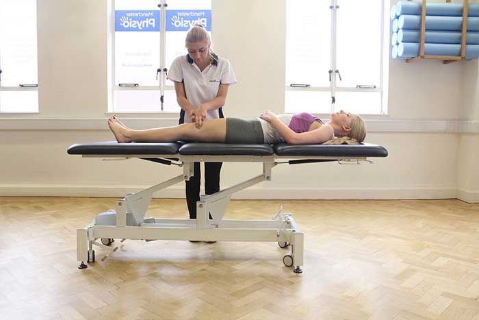Customer reciving a thigh massage while in a relaxed position in Manchester Physio Clinic