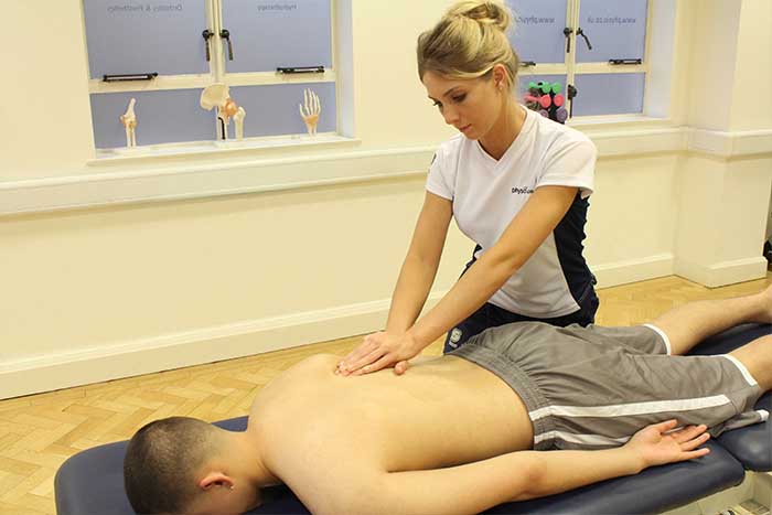 Customer receiving a lower back massage while in a relaxed position in Manchester Physio Clinic