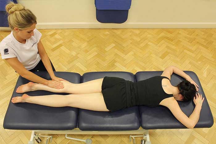 Customer receiving a calf massage while in a relaxed position in Manchester Physio Clinic