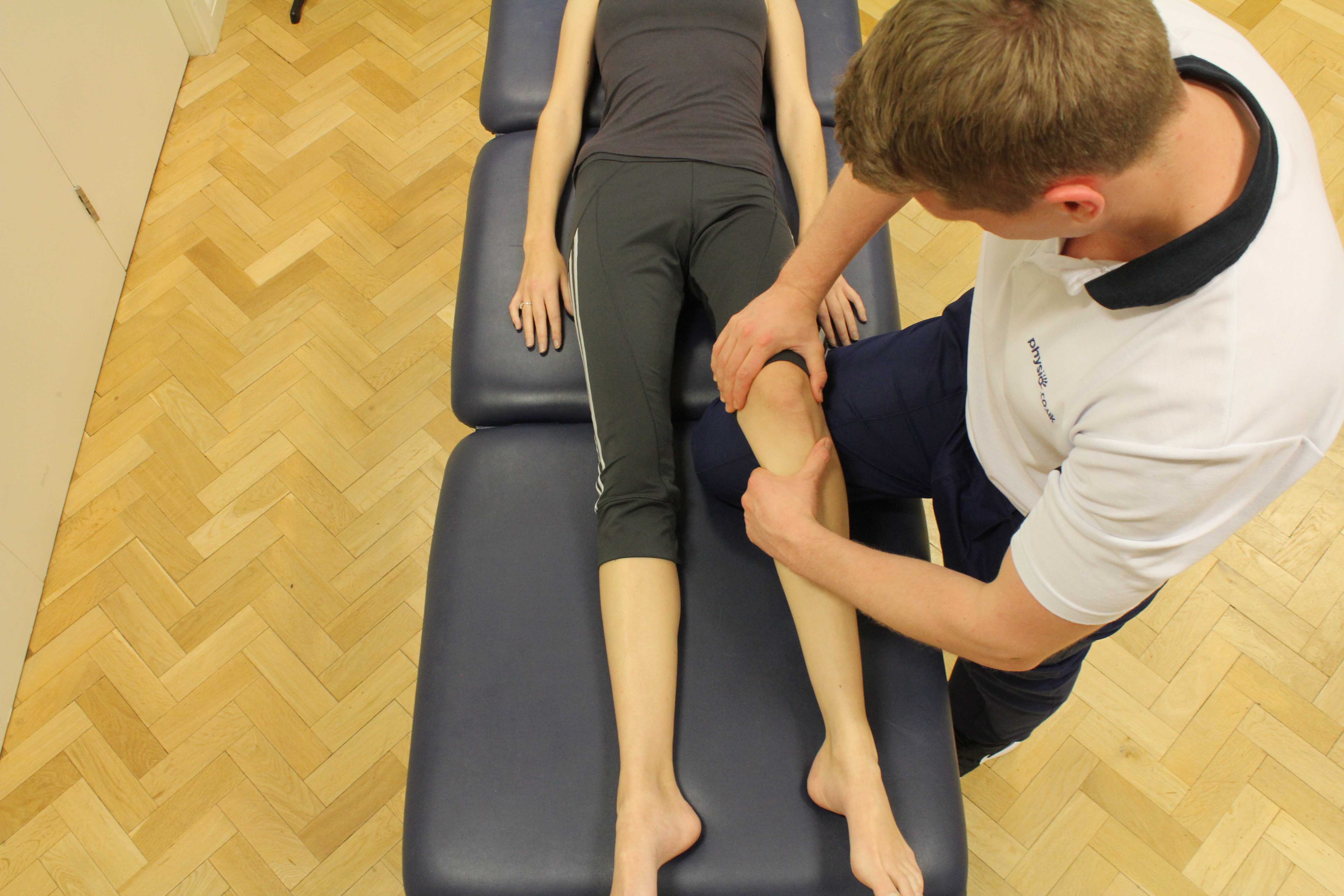 Therapist performing knee assessment
