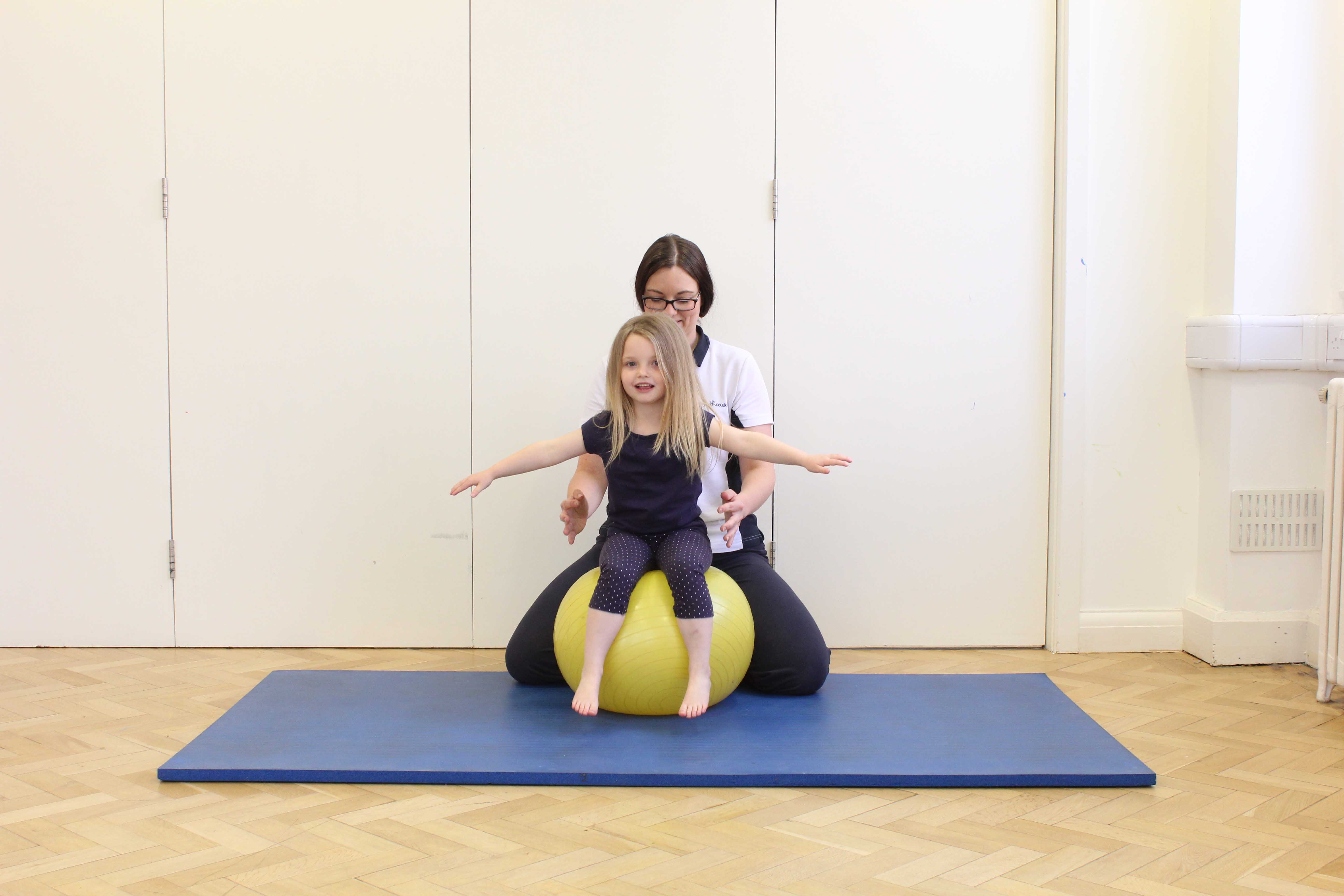 Trainig sitting balance and core stability on a gym ball under close supervision of a paediatric physiotherapist