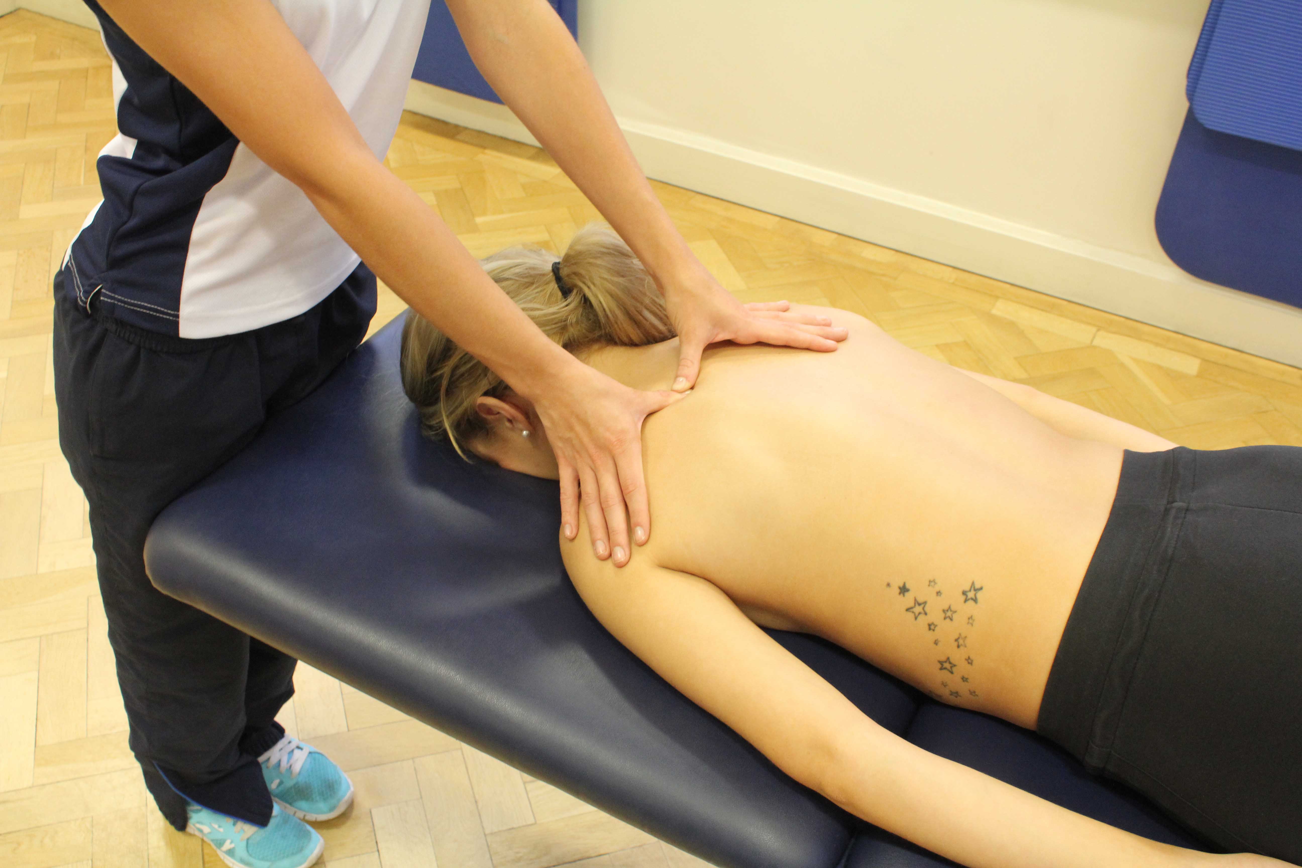 Trigger point massage of the muscles in the upper back by experienced therapist