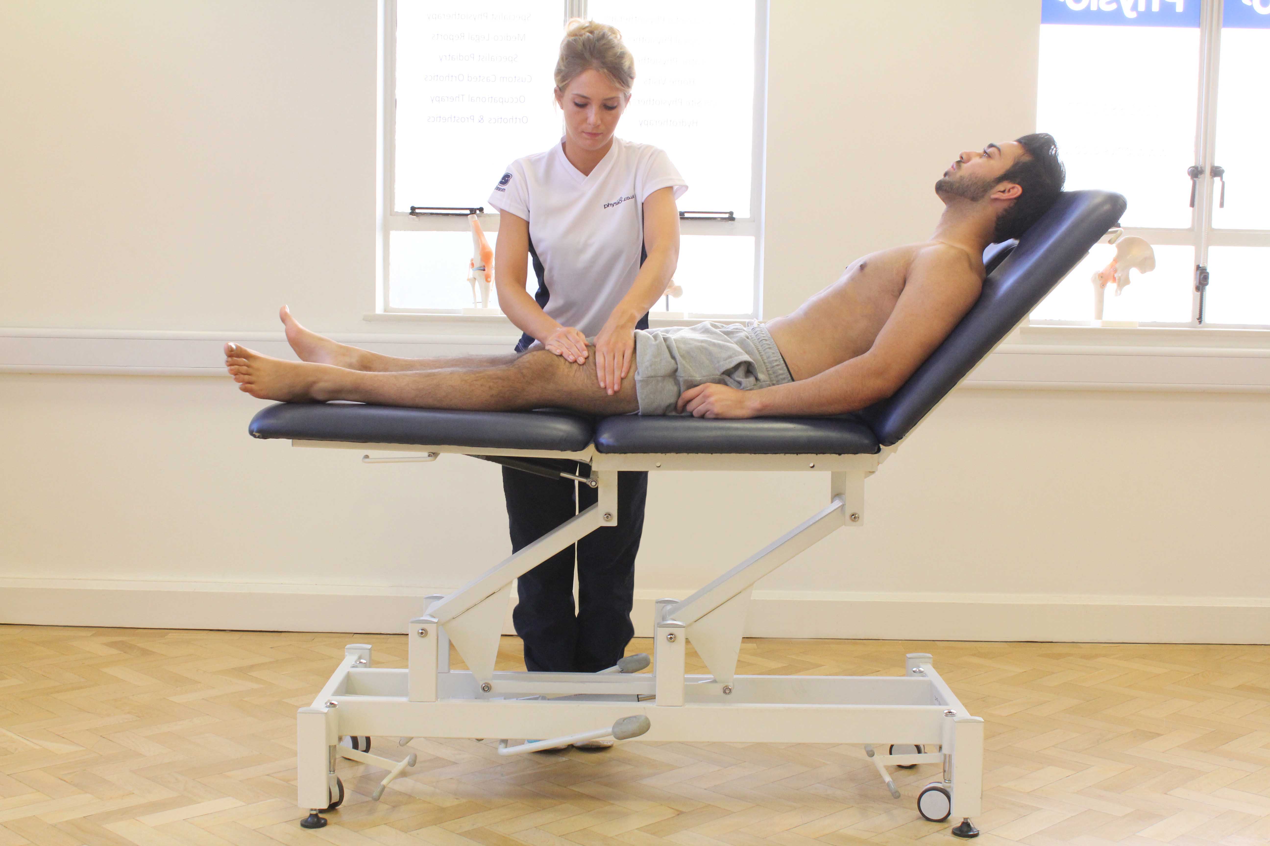 Rolling soft tissue massage of the quadricep muscles by experienced therapist