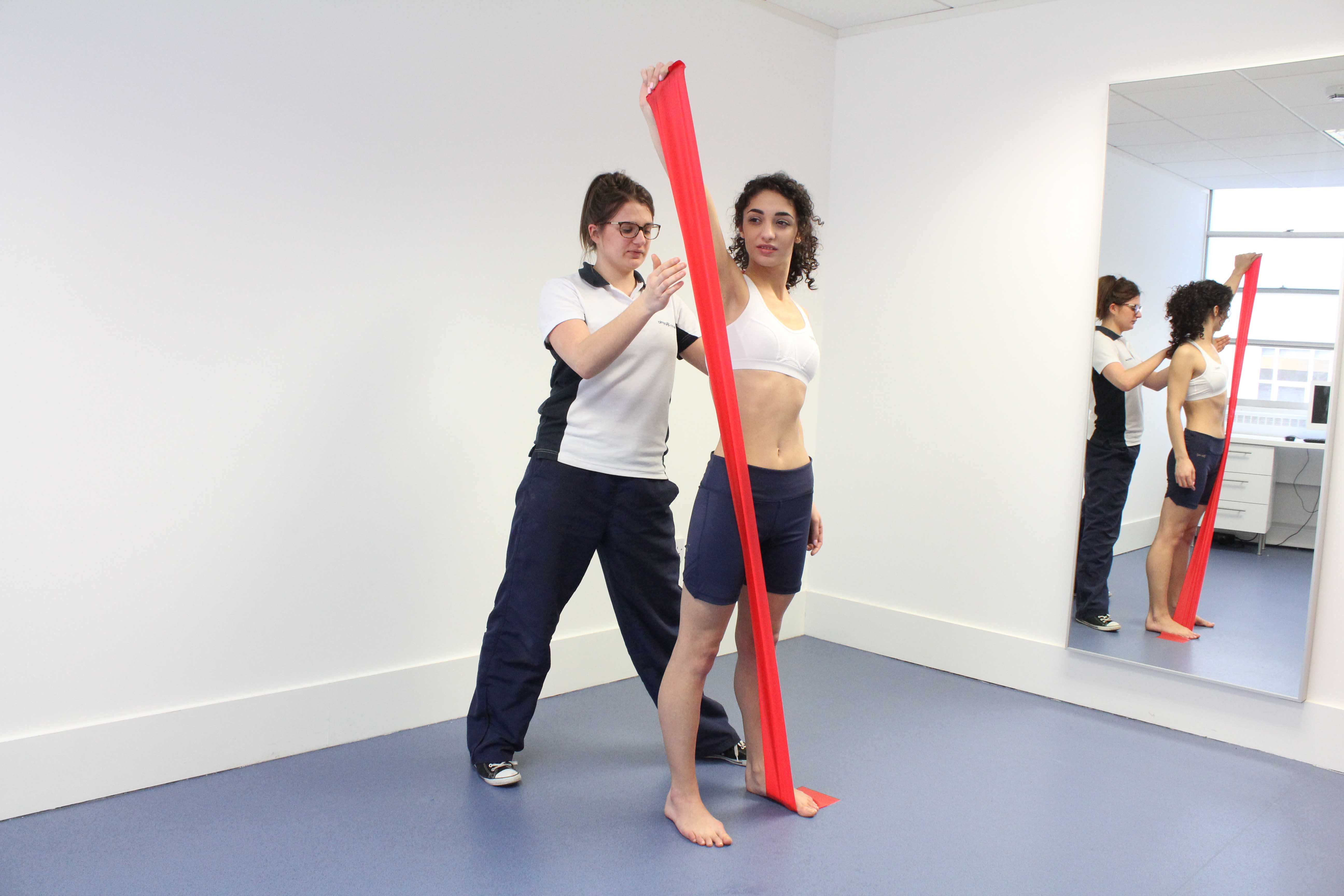Toning and strengthening the shoulder muscles using a resistance band under supervision of a Physiotherapist