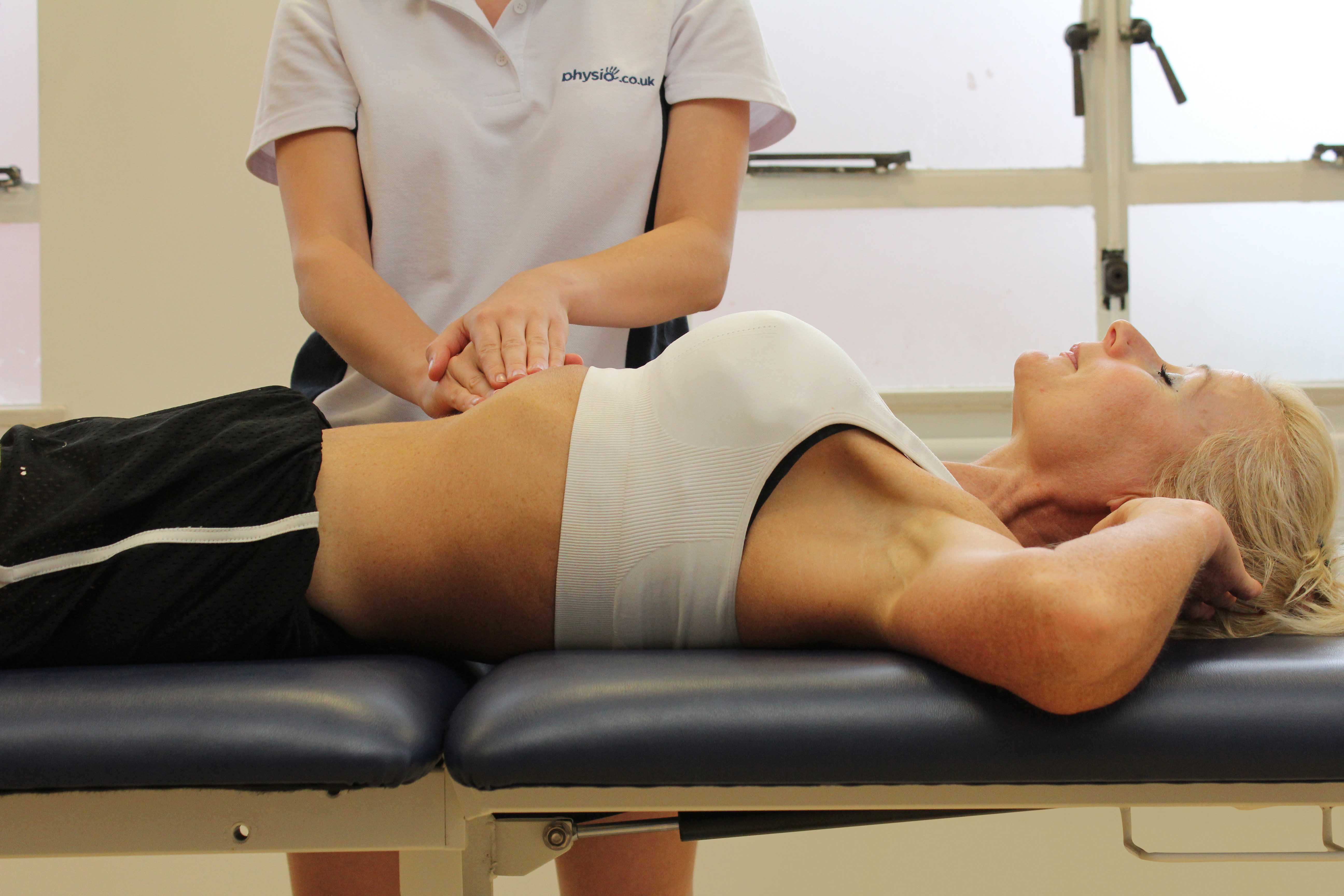 Soft tissue massage of the abdominal muscles by an experienced therapist