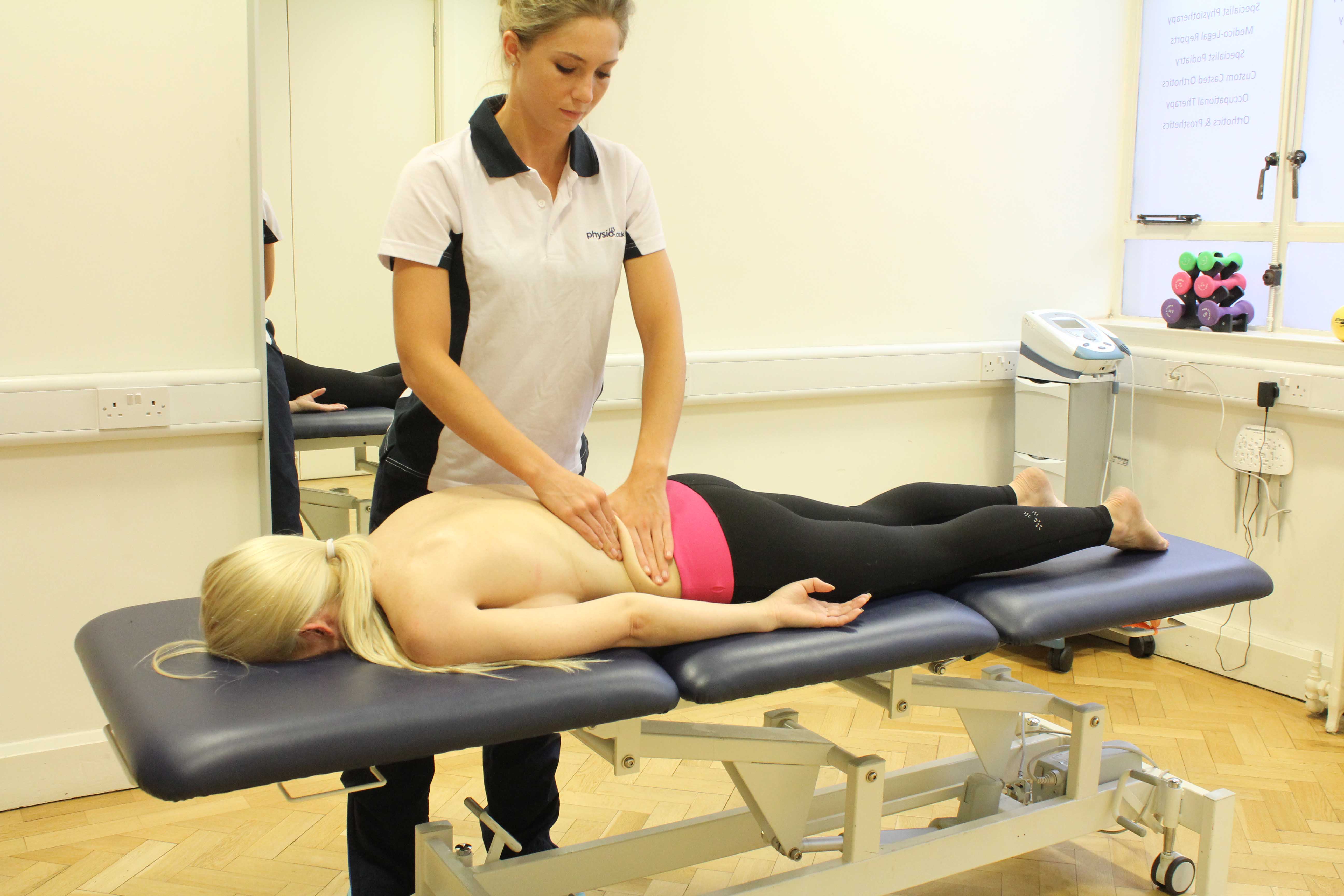 Rolling soft tissue massage of the lower back by an experienced massaage therapist