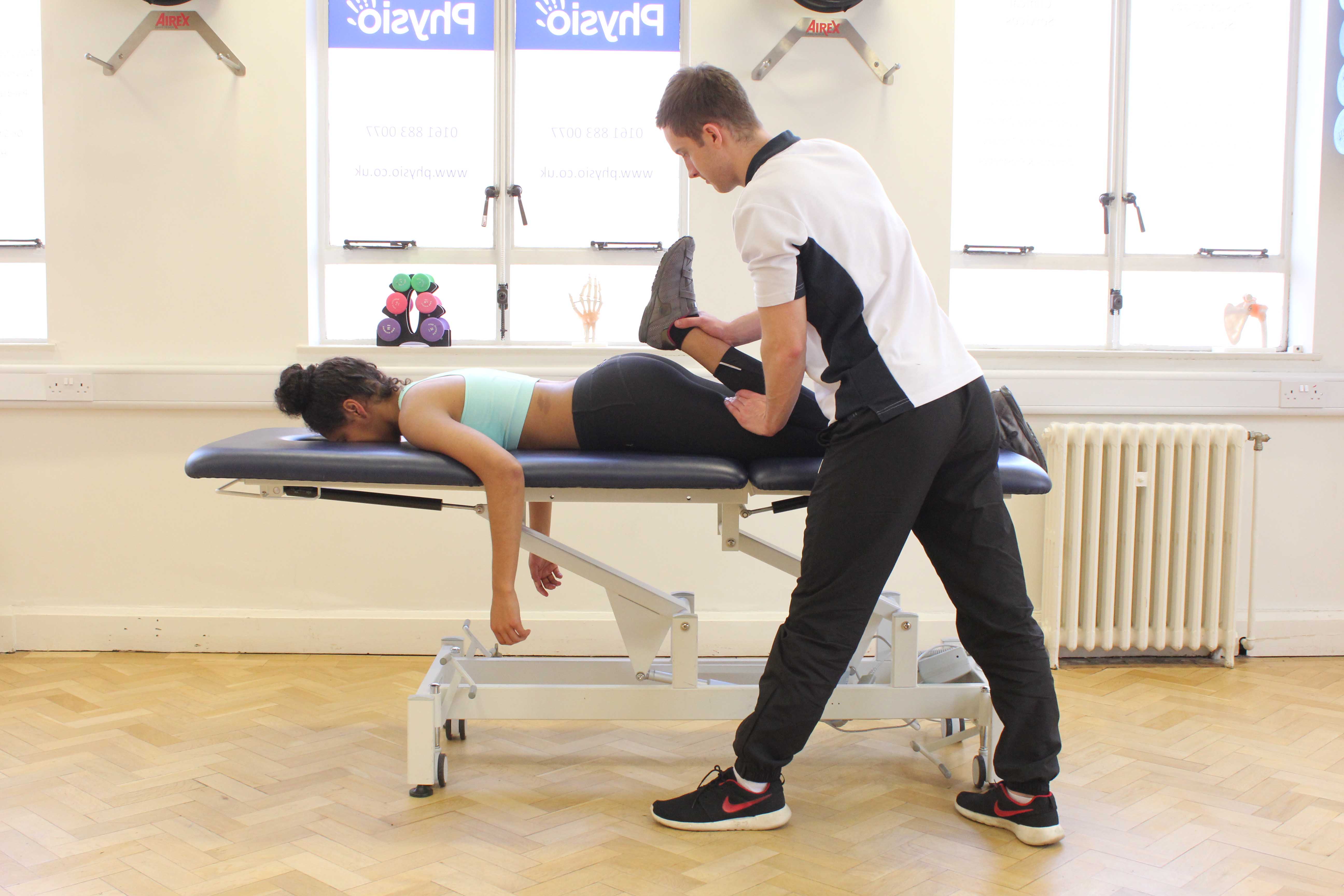 Physiotherapist performing quadriceps stretch