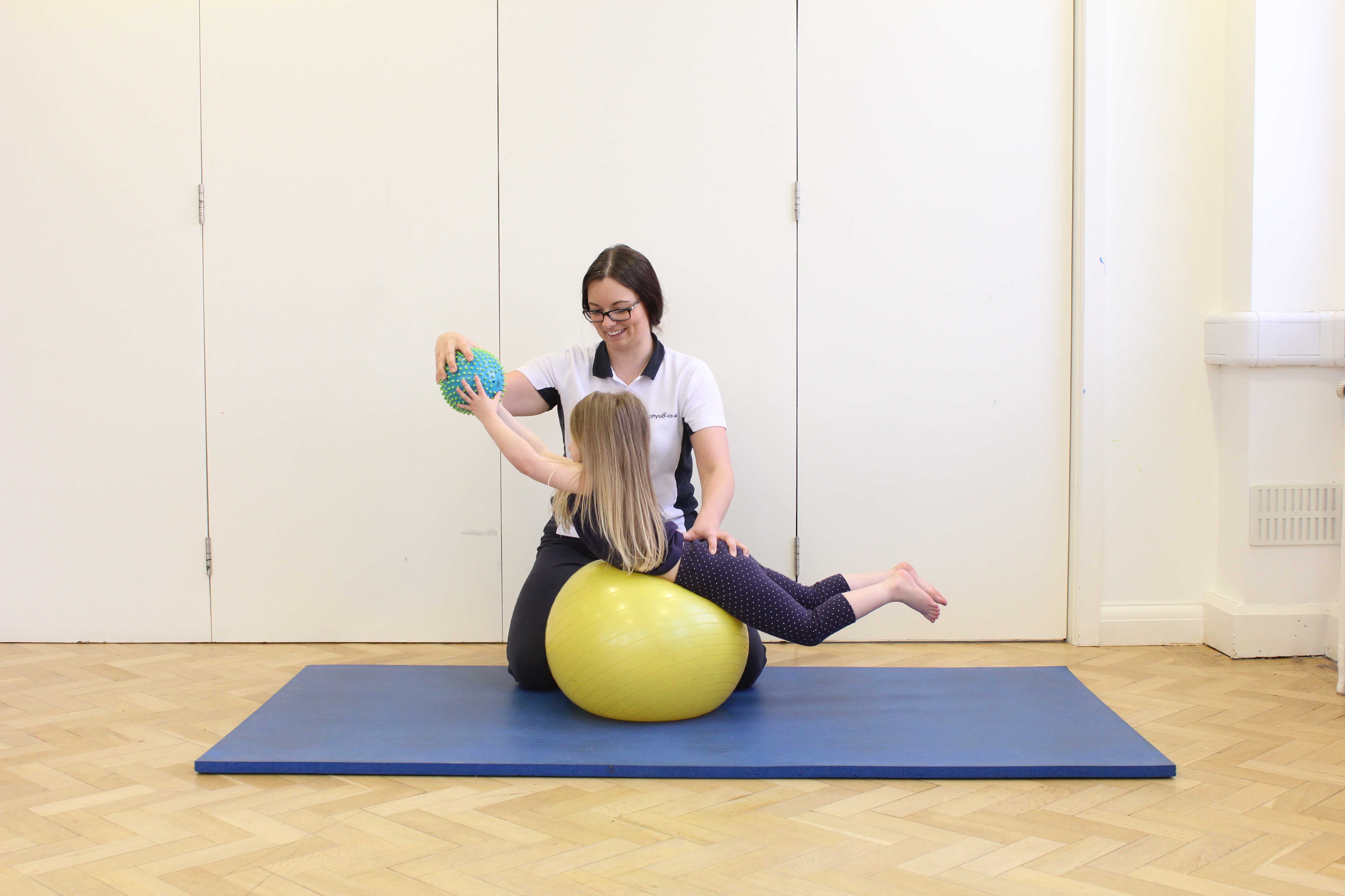 Stretching and toning exercises assisted by a paediatric physiotherapist