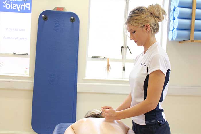 Customer reciving an upper back massage while in a relaxed position in Manchester Physio Clinic