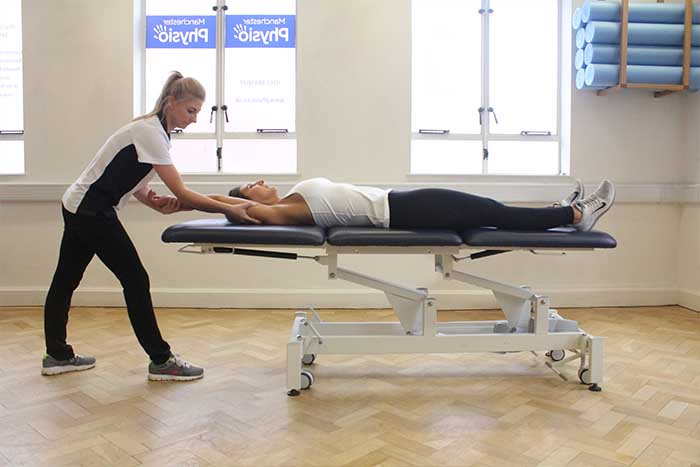 Customer receiving an arm stretch while in a relaxed position in Manchester Physio Clinic