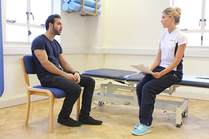 Customer having a conversation with massager in Manchester Physio Clinic