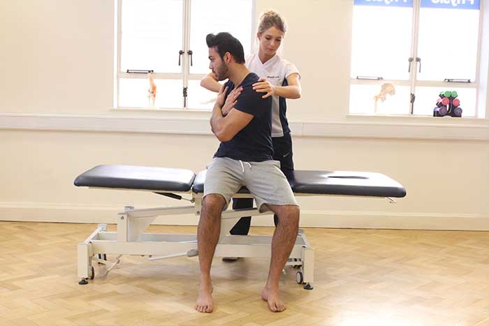 Customer reciving shoulder massage and abdominal stretches while in a sitting up position in Manchester Physio Clinic