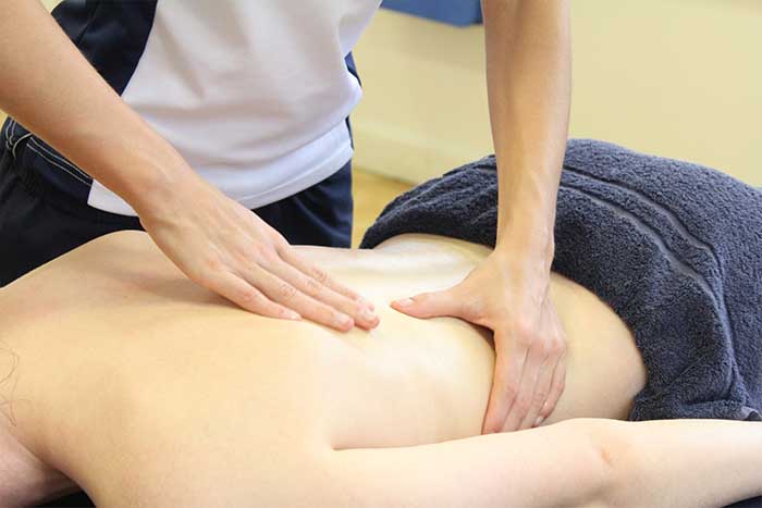 Customer reciving an upper back massage while in a relaxed position in Manchester Physio Clinic