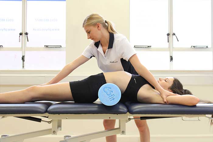 Customer receiving a back stretch while in a relaxed position in Manchester Physio Clinic