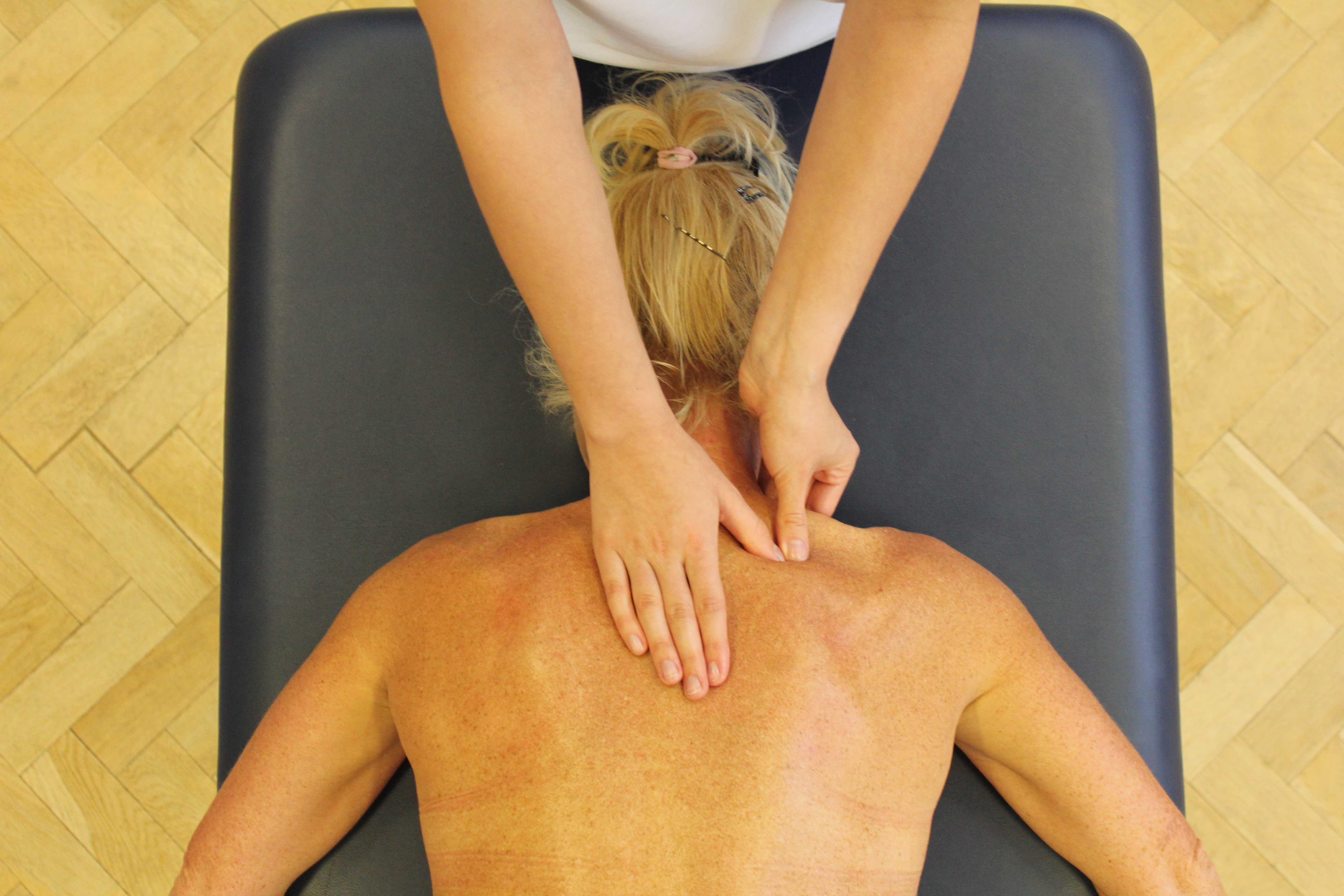 Trigger point massage of the trapezius muscle by a therapist