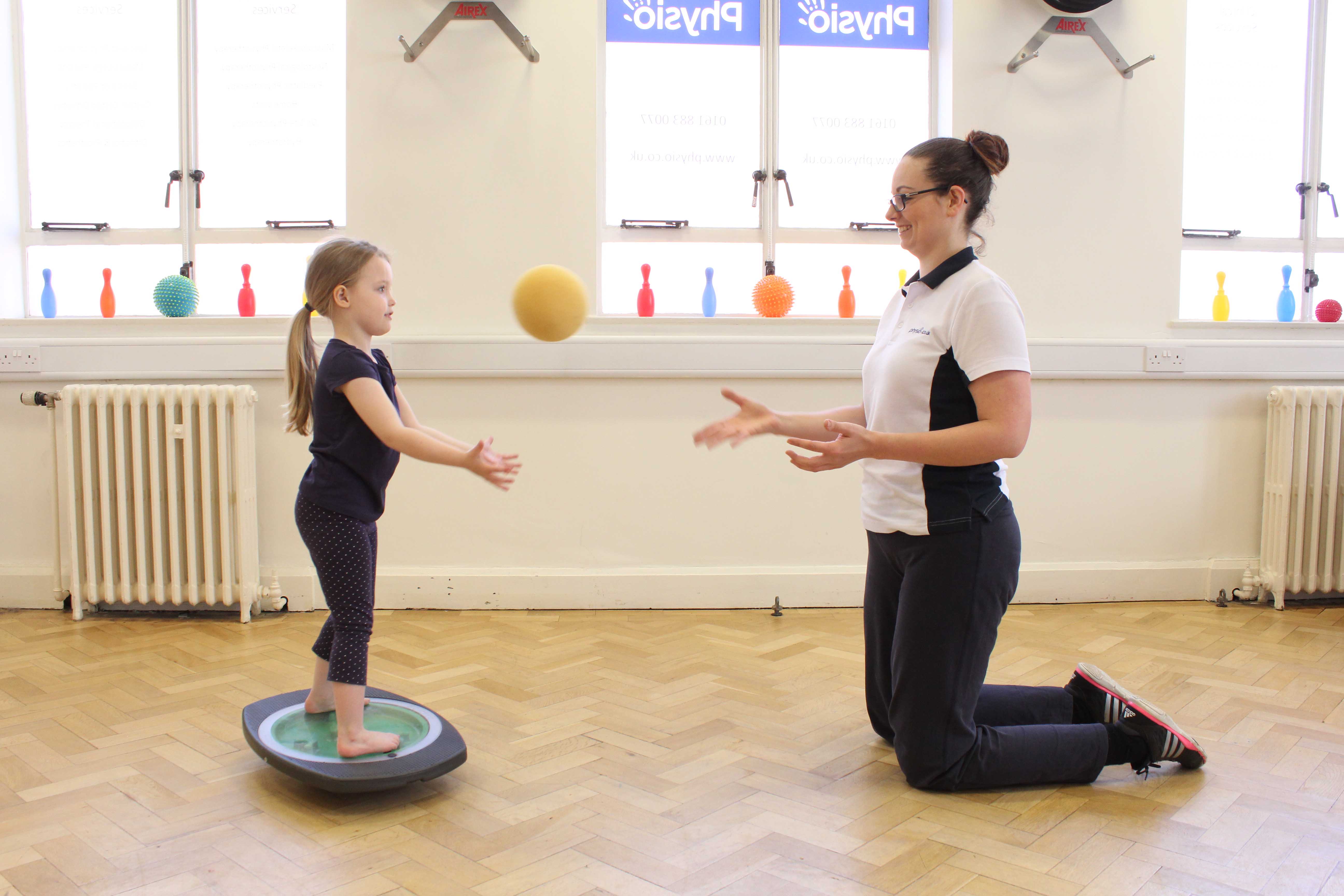 Balance training using a wobble board and ball with assistance from a paediatric neuro physiotherapist