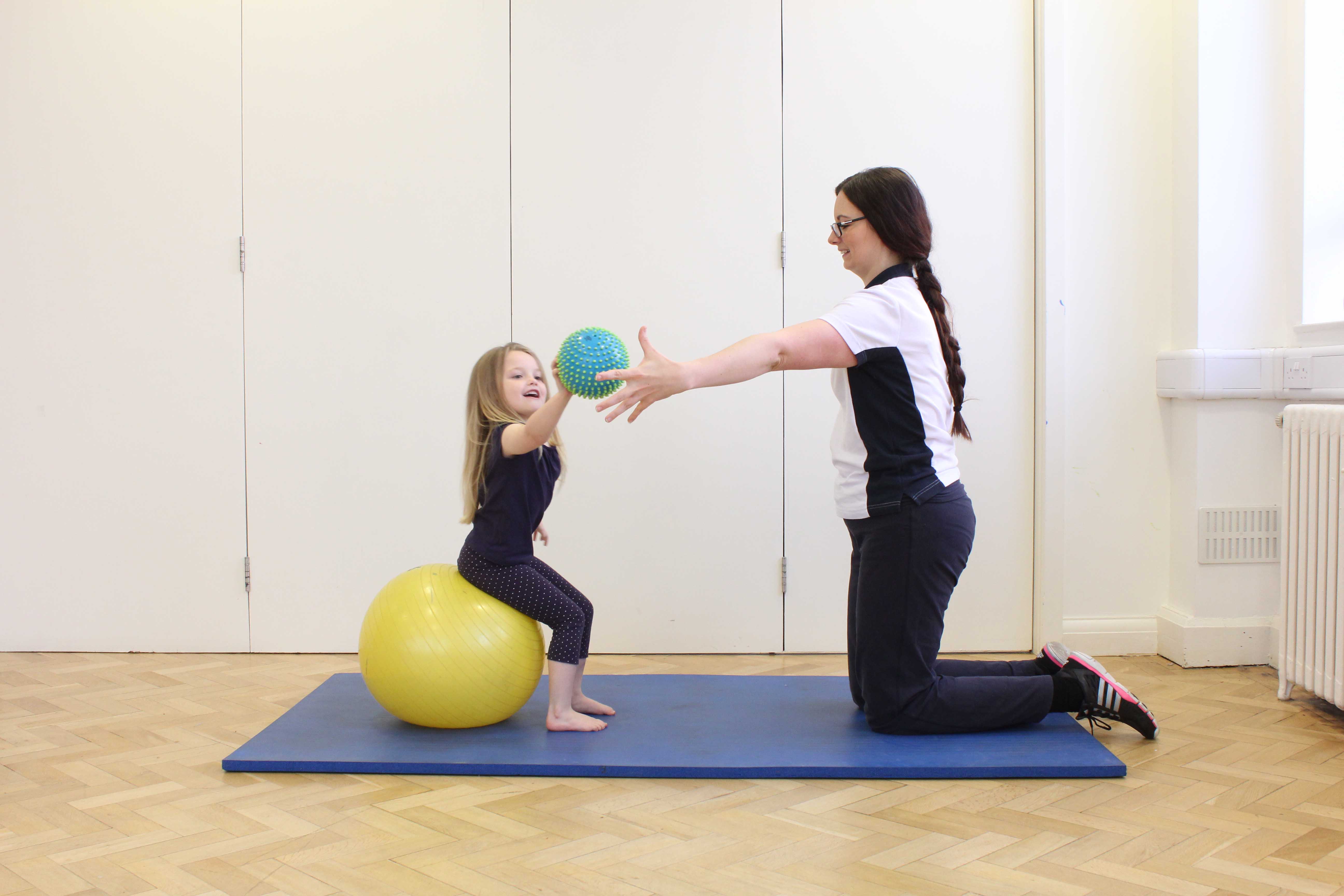 Physiotherapist encouraging increased range of movement with a reaching game.