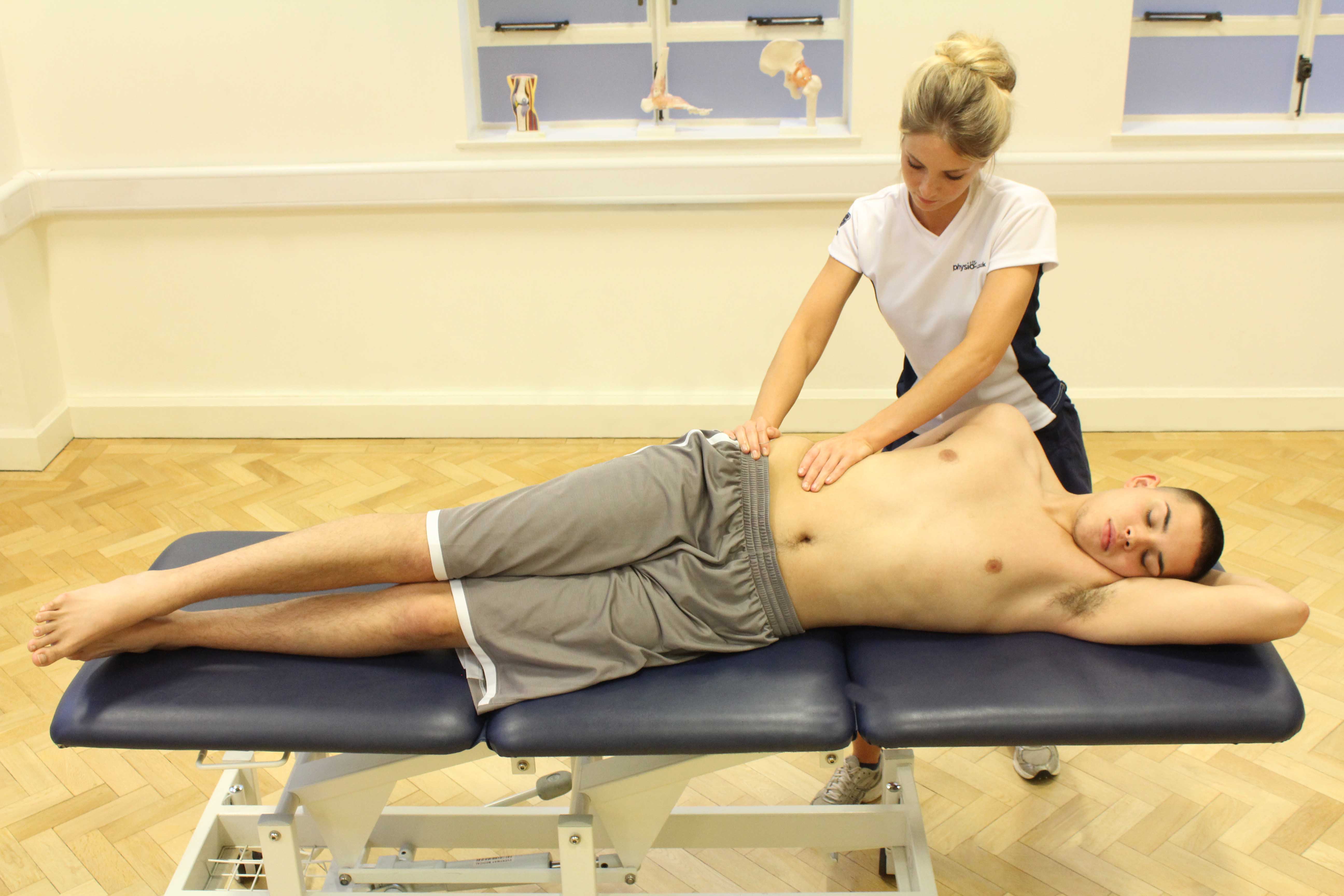 Experienced physiotherapist assessing available movement of the shoulder and scapular