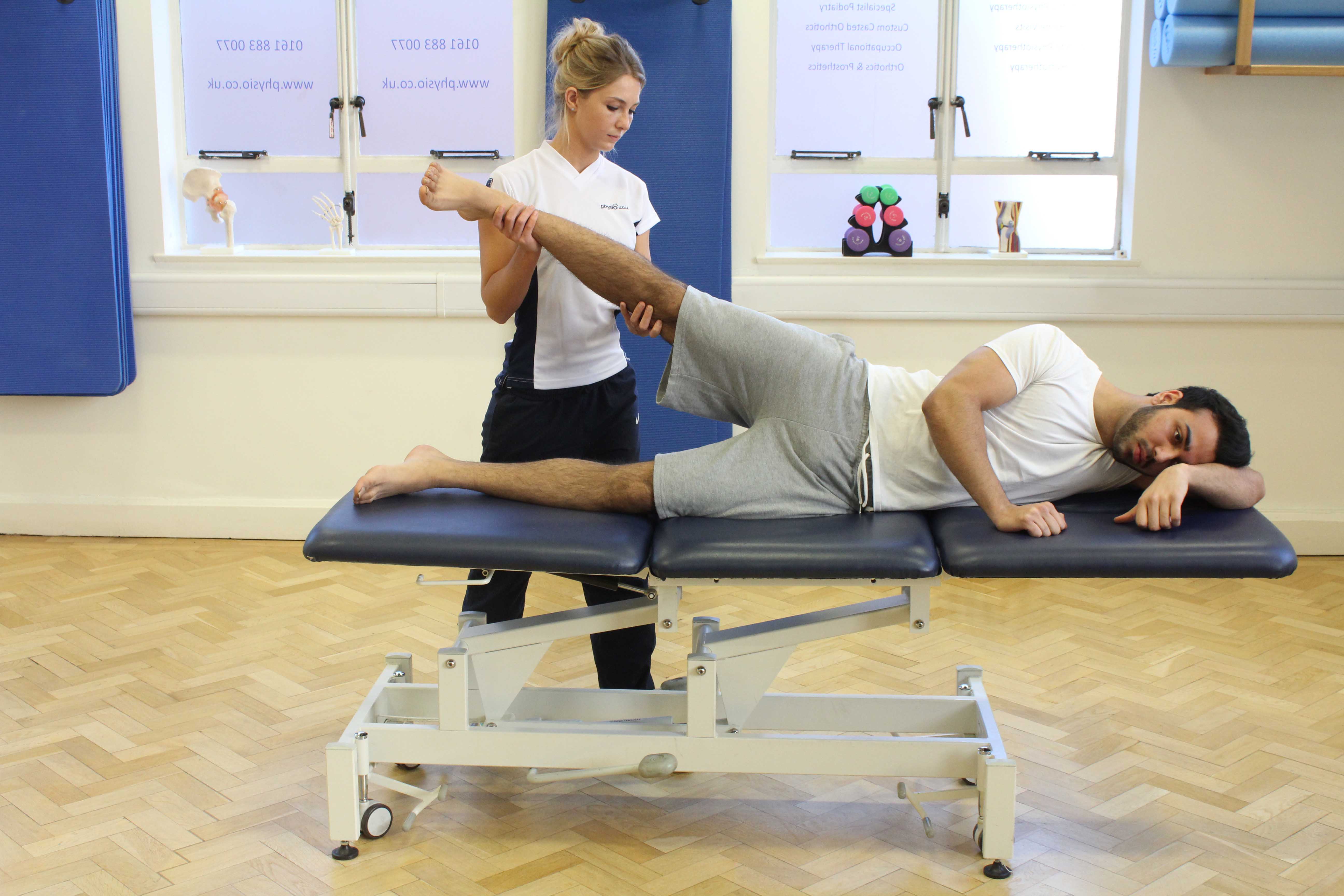 Performing passive and avtive calf stretches under supervision from a specialist MSK physiotherapist