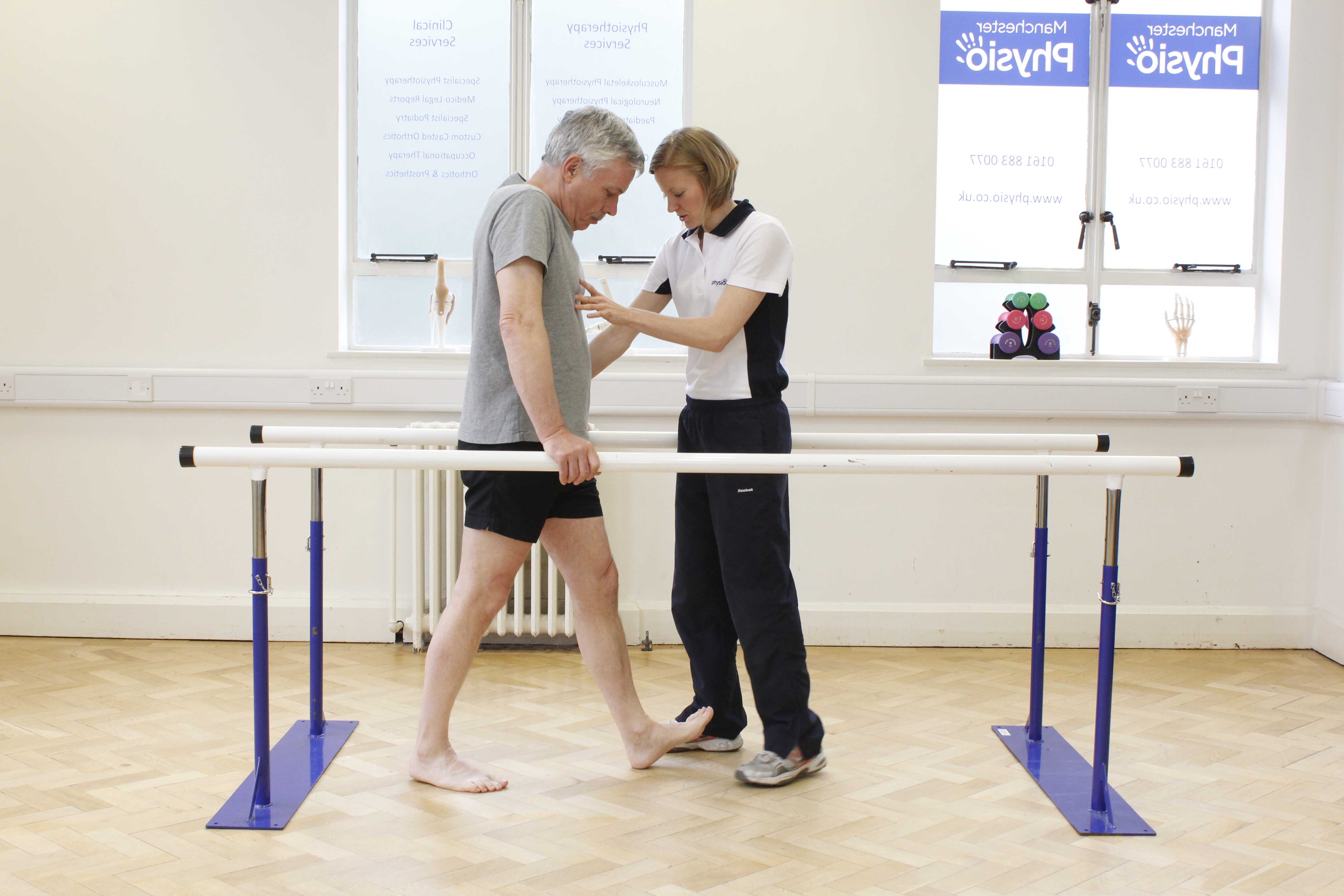 Gait re-education mobility exercises between the parallel bars under supervision of a physiotherapist